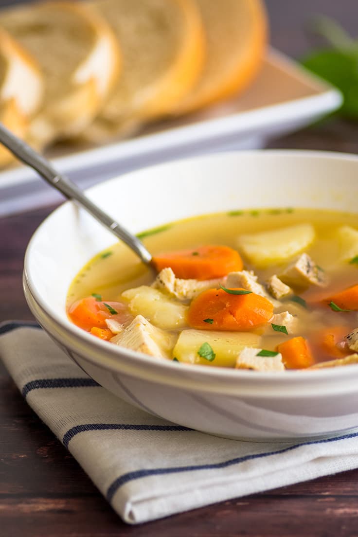 A white bowl of peasant chicken soup.