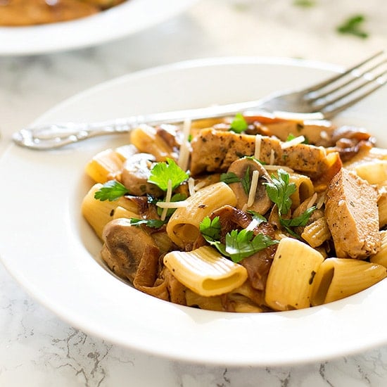 Lightened Up Copycat Carmela's Chicken - Chicken, mushrooms, and delicious caramelized onions cooked up in a wine and cream sauce and served over rigatoni. A lightened up version of the Macaroni Grill favorite. Recipe includes nutritional information, make-ahead and low-yield instructions. From BakingMischief.com