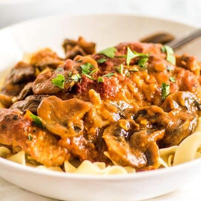 This Easy Chicken Cacciatore is boneless, skinless chicken thighs and mushrooms simmered in a rich tomato sauce and served over a bed of egg noodles for a fabulous weeknight meal. | Easy Dinners | Easy Pasta | Chicken Pasta |
