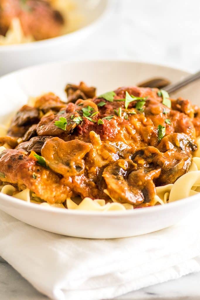 This Easy Chicken Cacciatore is boneless, skinless chicken thighs and mushrooms simmered in a rich tomato sauce and served over a bed of egg noodles for a fabulous weeknight meal. | Easy Dinners | Easy Pasta | Chicken Pasta |