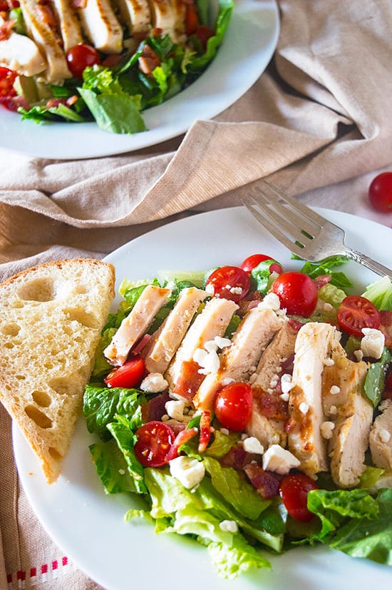My favorite hearty chicken salad, loaded with garlic chicken, tomatoes, bacon, and feta. So good, you won't mind eating your greens! Recipe includes nutritional information and make-ahead instructions.
