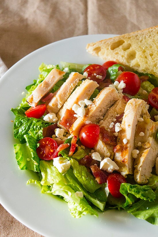 My favorite hearty chicken salad, loaded with garlic chicken, tomatoes, bacon, and feta. So good, you won't mind eating your greens! Recipe includes nutritional information and make-ahead instructions.