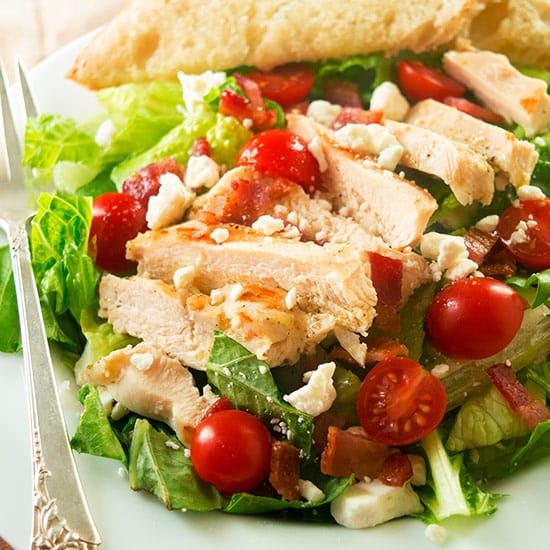 My favorite hearty chicken salad, loaded with garlic chicken, tomatoes, bacon, and feta. So good, you won't mind eating your greens! Recipe includes nutritional information and make-ahead instructions.