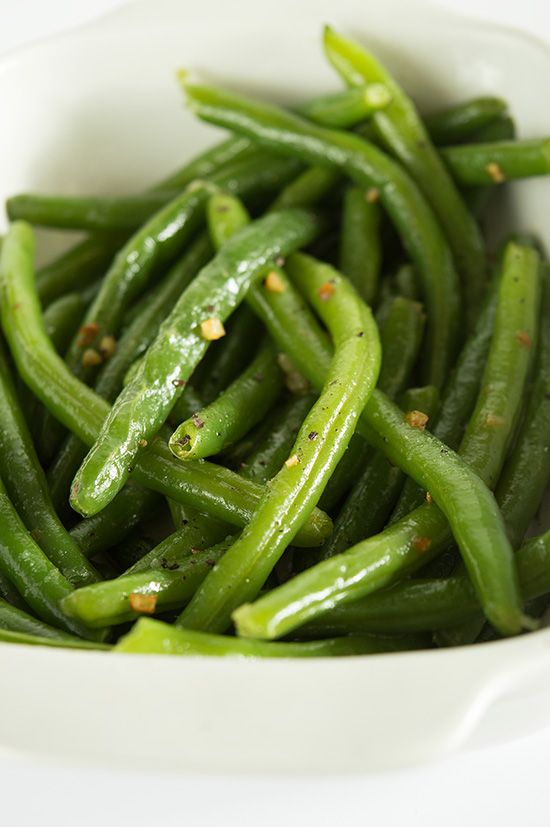 Butter and garlic green beans in a white dish.