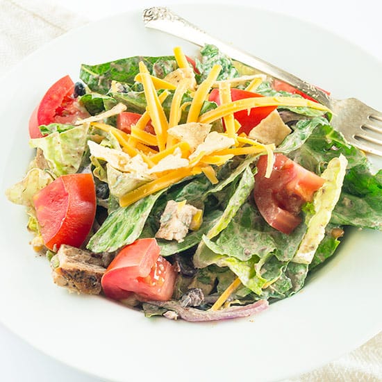 A slightly spicy chicken salad packed with black beans, corn, red onions, and cheese and topped with a chipotle cilantro sour cream dressing. This salad can easily be made burn-your-taste-buds-off-spicy if you are one of those... Recipe includes nutritional information, small-yield, make-ahead, and freezer instructions. From BakingMischief.com