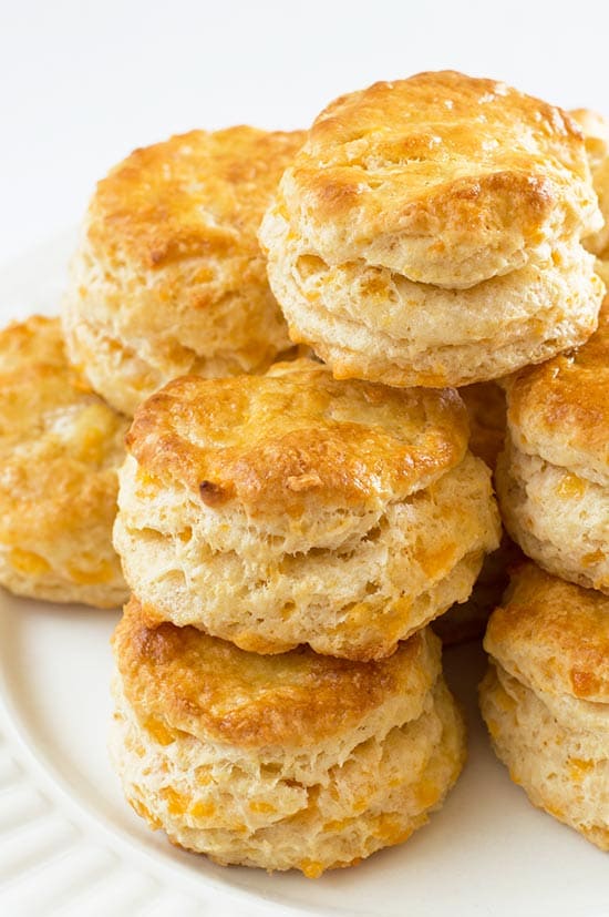 Cheddar Cheese Scones stacked on a white plate.