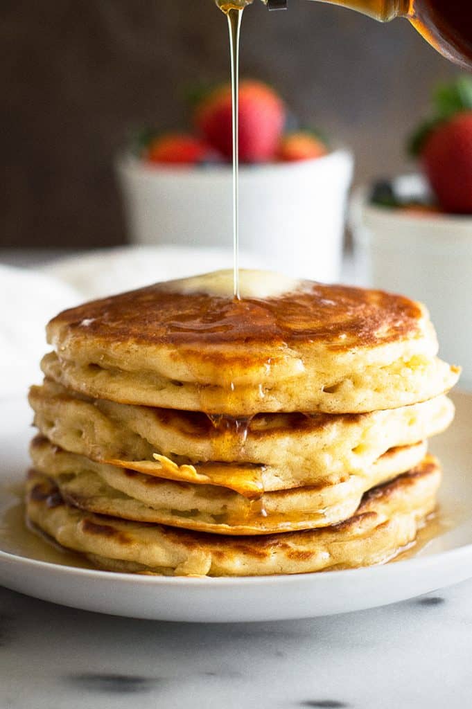 Photo of buttermilk pancakes made with leftover buttermilk on a white plate.