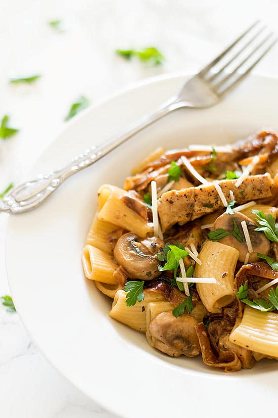 Lightened Up Copycat Carmela's Chicken - Chicken, mushrooms, and delicious caramelized onions cooked up in a wine and cream sauce and served over rigatoni. A lightened up version of the Macaroni Grill favorite. Recipe includes nutritional information, make-ahead and low-yield instructions. From BakingMischief.com