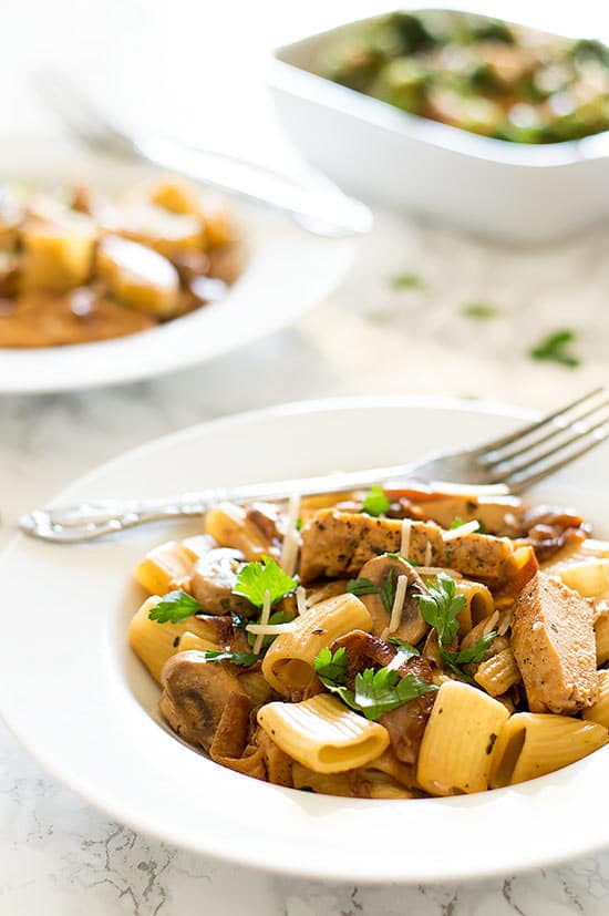 Lightened Up Copycat Carmela's Chicken - Chicken, mushrooms, and delicious caramelized onions cooked up in a wine and cream sauce and served over rigatoni. A lightened up version of the Macaroni Grill favorite. Recipe includes nutritional information, make-ahead and low-yield instructions. From BakingMischief.com