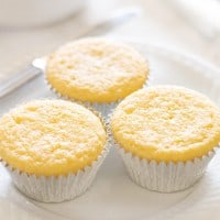 Three cornbread muffins on a white plate.
