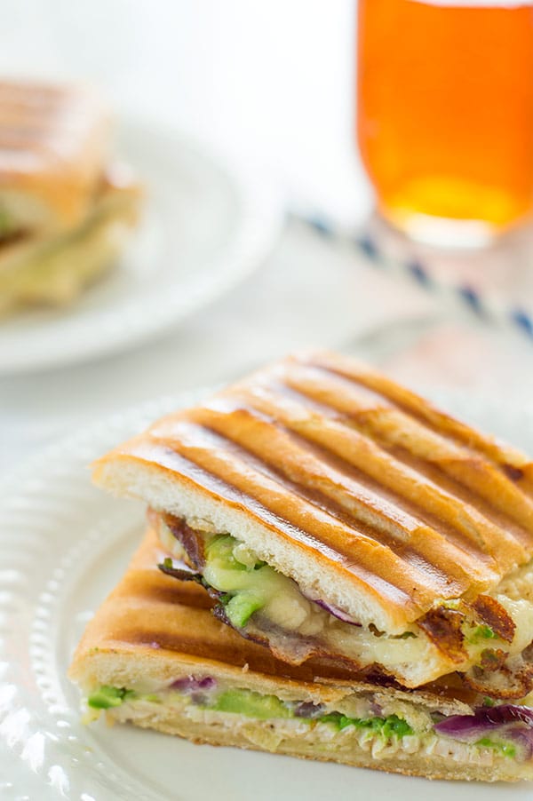 My favorite quick weeknight panini with chipotle aioli, crunchy red onions, sliced turkey, melty cheese, and avocado. Recipe includes nutritional information. From BakingMischief.com