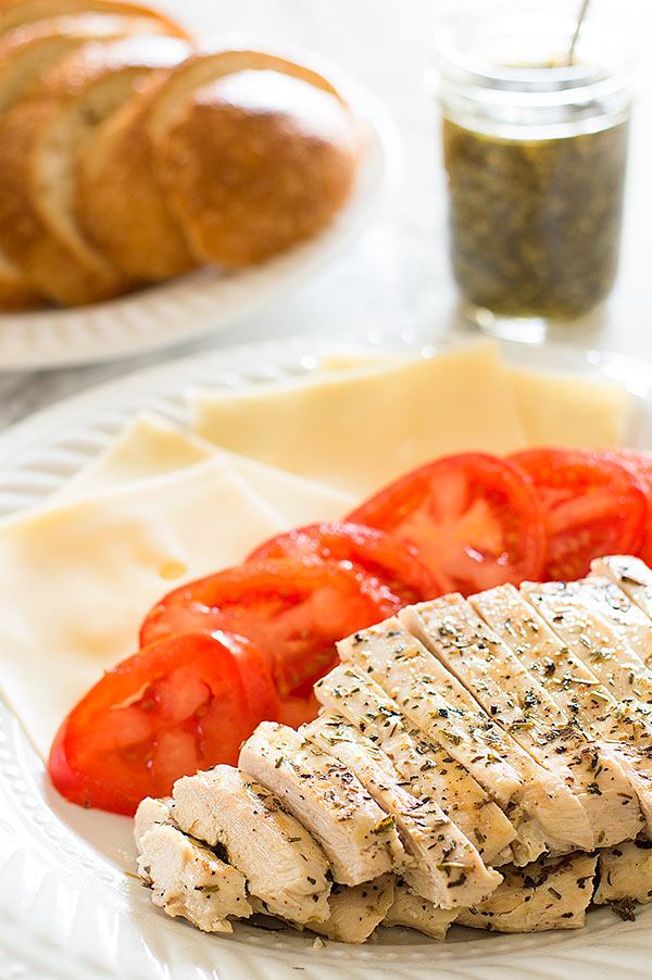 Ingredients for a pesto chicken sandwich on a plate.