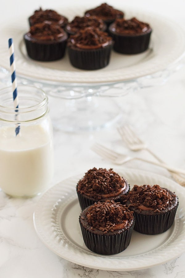 Insanely chocolatey Brooklyn Blackout Cupcakes made with three different types of chocolate, stuffed with a creamy chocolate pudding, and topped with sprinkles and a chocolate glaze. Recipe includes nutritional information. From BakingMischief.com