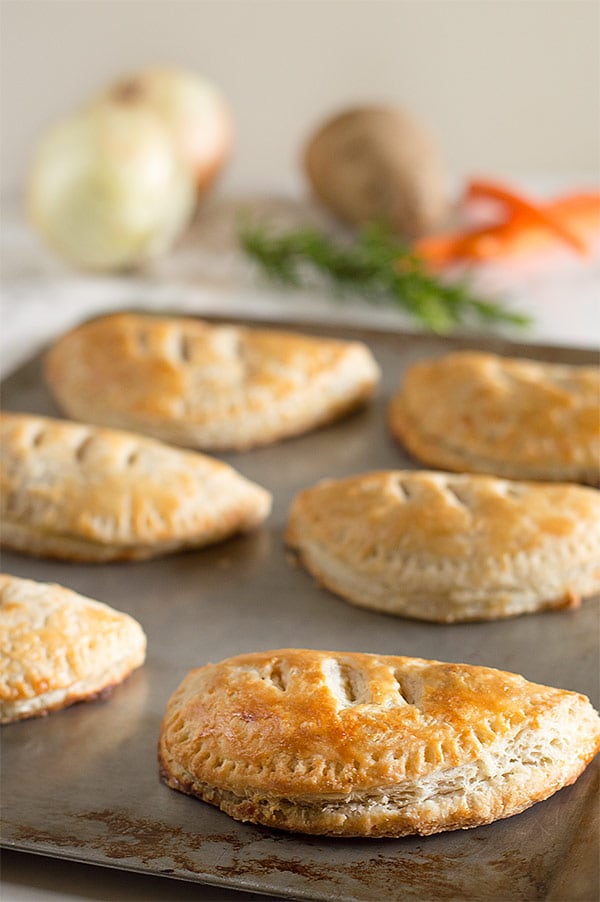 Beef pasties on a baking sheet.
