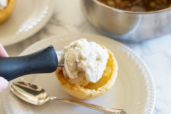 Apple pie in sundae form! Tart Granny Smith apples cooked with brown sugar and cinnamon and dowsed in caramel sauce. Served over vanilla ice cream in a flaky homemade (easy!) buttermilk pie crust shell. Recipe includes nutritional information. From BakingMischief.com