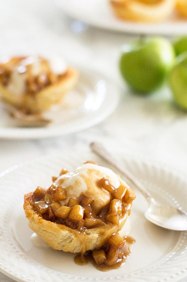 Apple pie in sundae form! Tart Granny Smith apples cooked with brown sugar and cinnamon and dowsed in caramel sauce. Served over vanilla ice cream in a flaky homemade (easy!) buttermilk pie crust shell. Recipe includes nutritional information. From BakingMischief.com