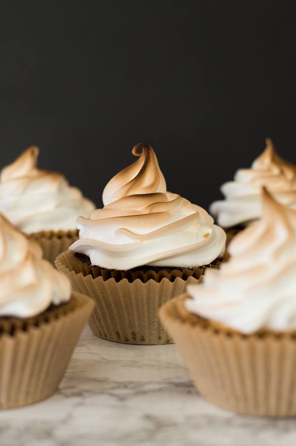 Cupcakes frosted with marshmallow frosting and toasted.
