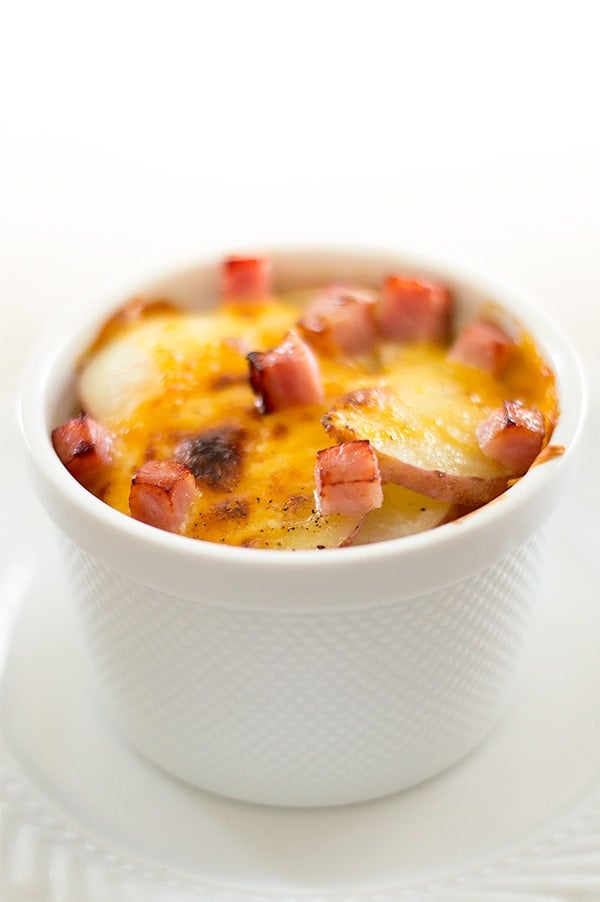 Single-serve scalloped potatoes in a white ramekin.