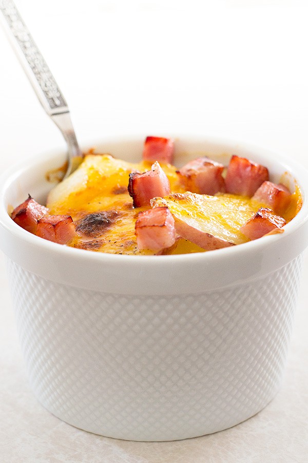 Scalloped potatoes for one in a white bowl.
