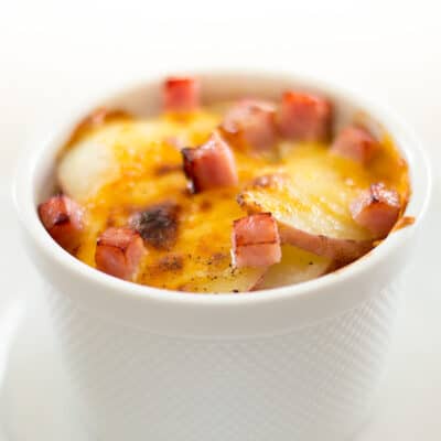 Scalloped potatoes for one in a white bowl.