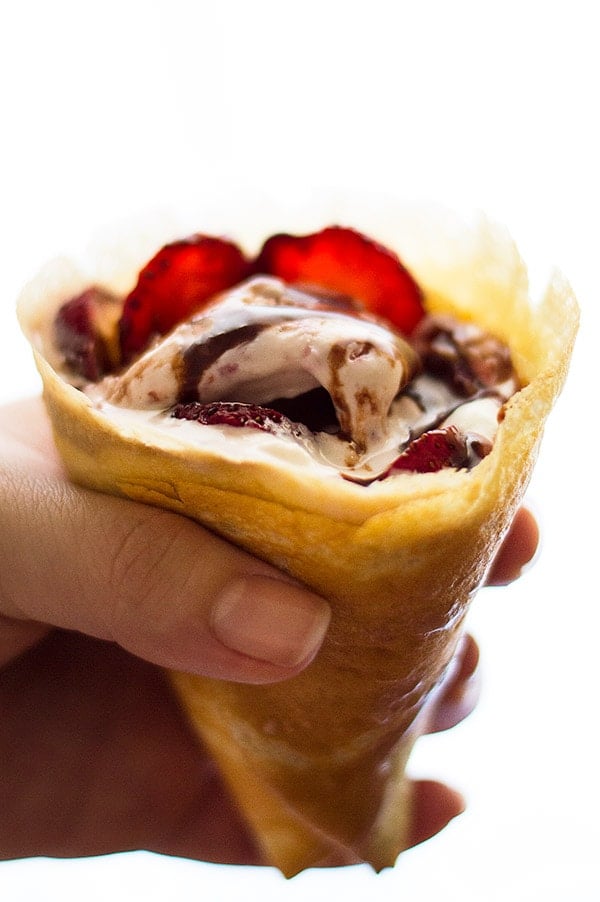 A hand holding a Strawberry and Nutella Crepe Cone.
