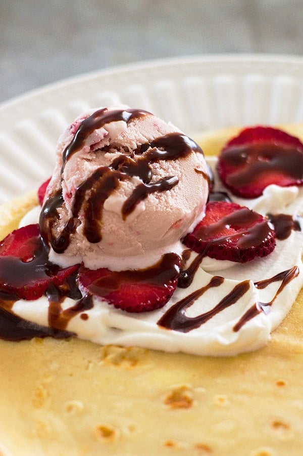 Close up of Strawberry and Nutella Crepe Cone on a plate before being rolled.