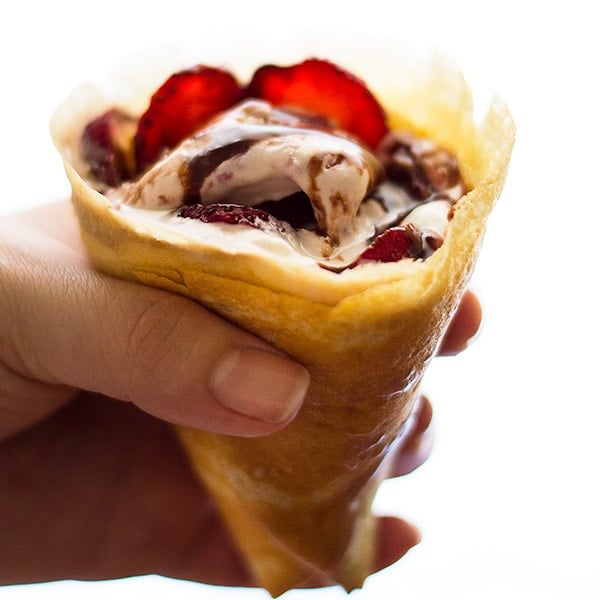 A hand holding a Strawberry and Nutella Crepe Cone.