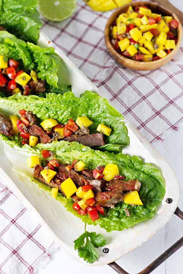 Chili lime beef lettuce wrap tacos on a white plate.