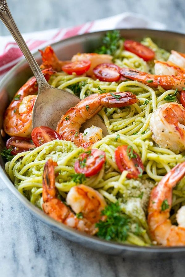 Shrimp pesto pasta with serving spoon.