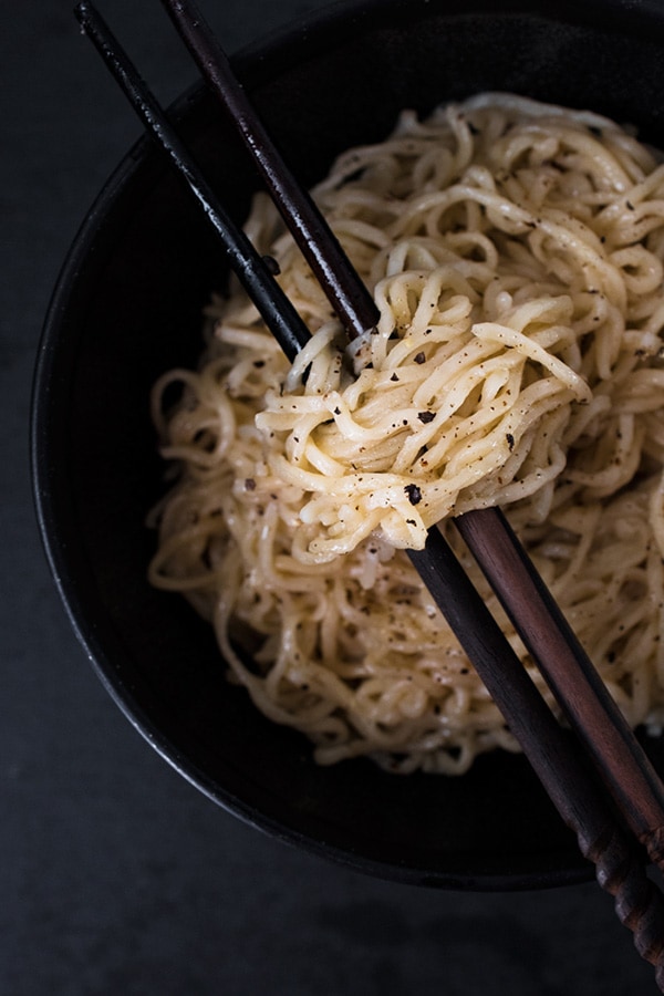 Ramen Cacio e pepe in a black bowl.