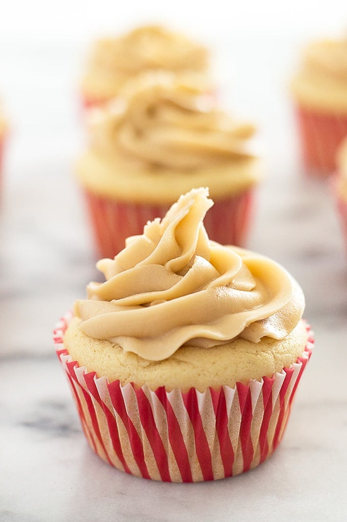 Apple pie cupcake with caramel frosting on marble countertop.
