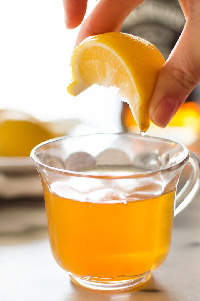 Lemon being squeezed into chai hot toddy.