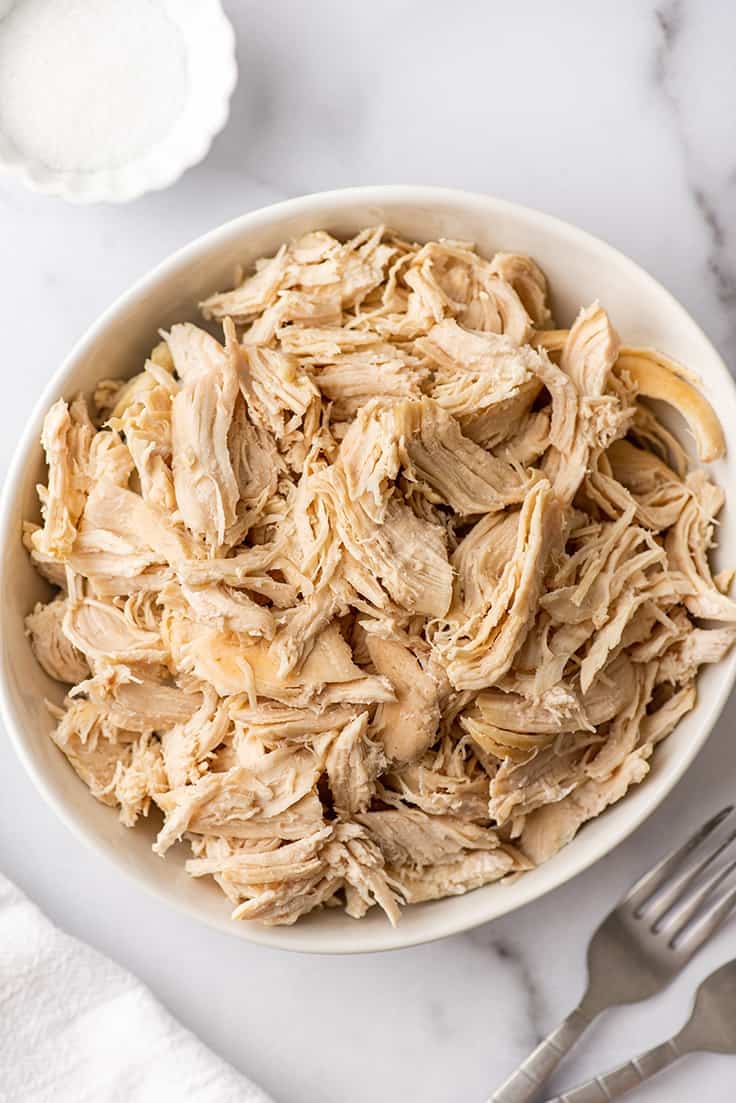 Shredded chicken in a white bowl.