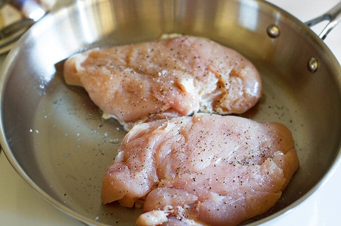 Chicken being browned in a pan for shredding.