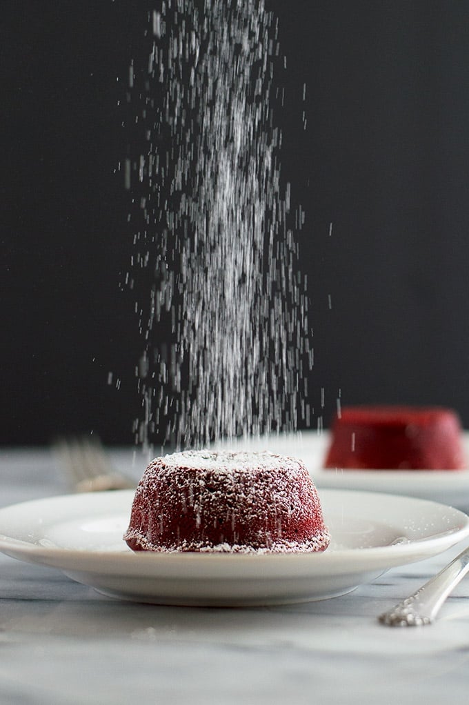 Powdered sugar falling on red velvet lava cake.