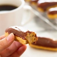 These cute and delicious Mini Pumpkin Eclairs are topped with chocolate glaze and filled with rich pumpkin pastry cream. Recipe includes nutritional information. From BakingMischief.com