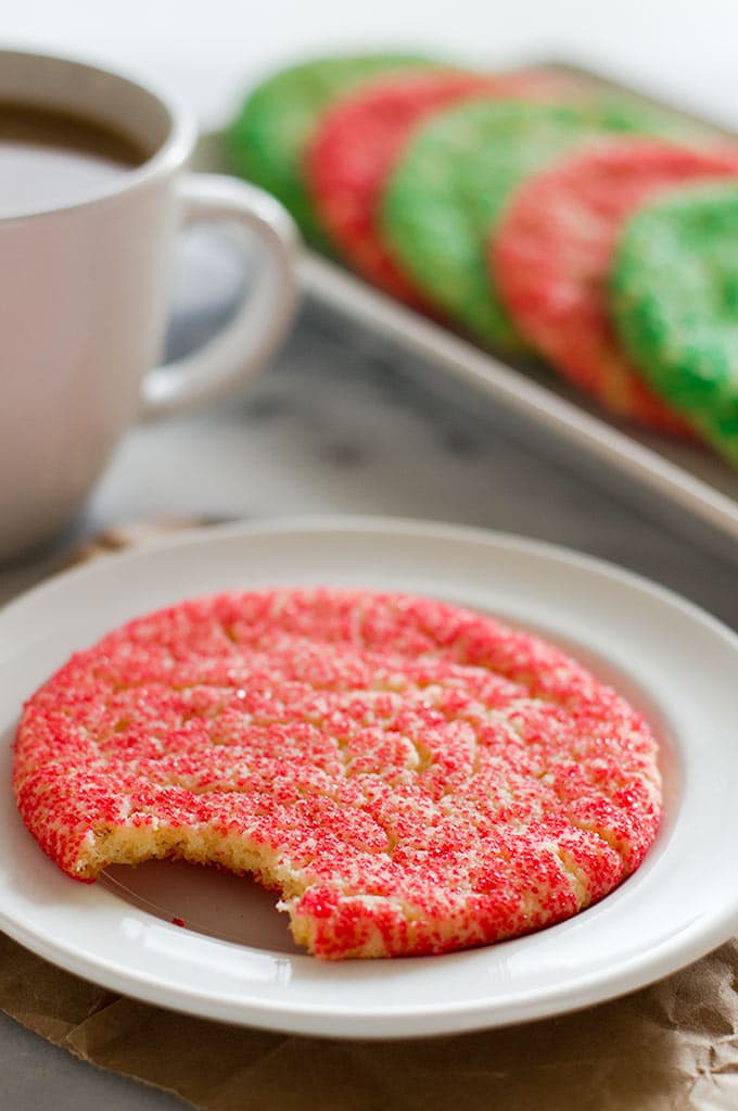 Giant Christmas cookie with a bite out of it on a white plate.