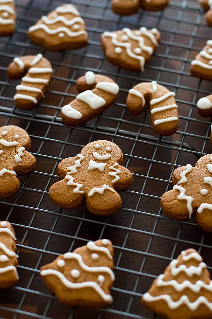 Decorated mini gingerbread cookies on a baking rack.