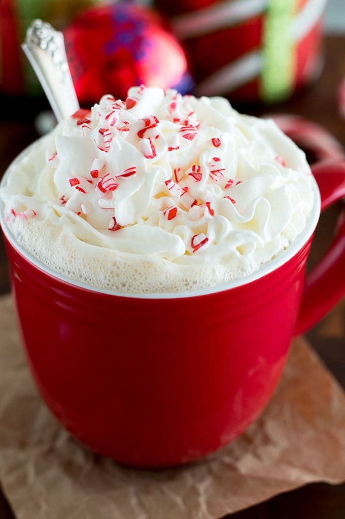 Peppermint white chocolate mocha in a red mug with whipped cream and crushed candy cane.