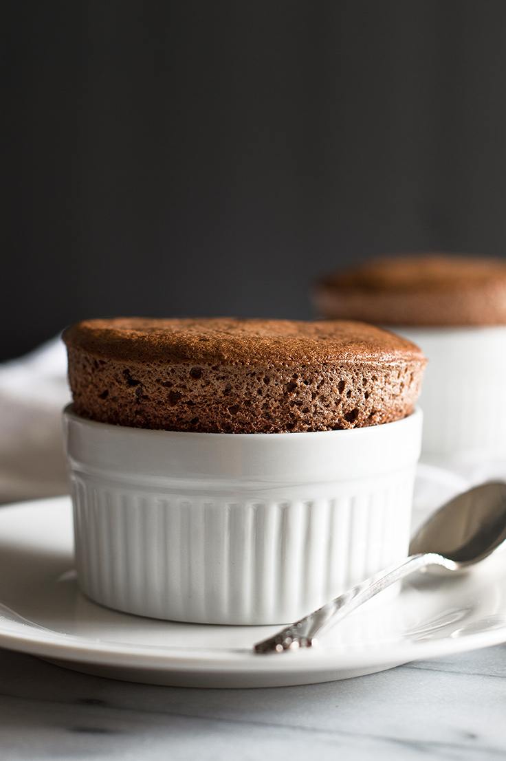 Two chocolate souffles on a marble counter.