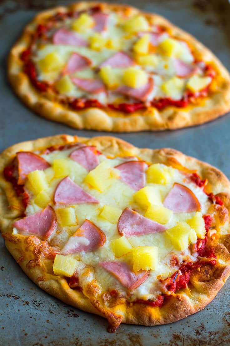 Hawaiian Naan pizza on a baking sheet.
