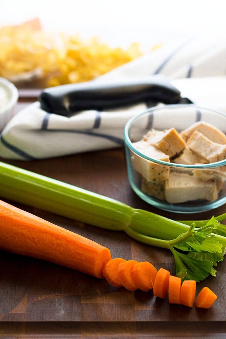 Photo of the ingredients for chicken noodle soup for one on a cutting board.