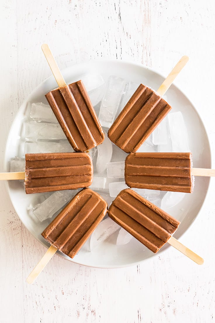 Homemade pudding pops on a plate of ice.