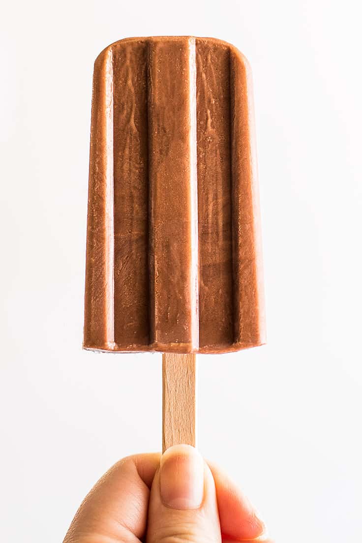 Hand holding a single pudding pop.