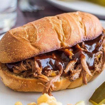 Slow cooker tri-tip sandwich on a white plate.