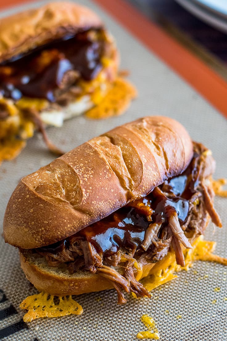 Slow cooker tri-tip sandwiches on a baking sheet.