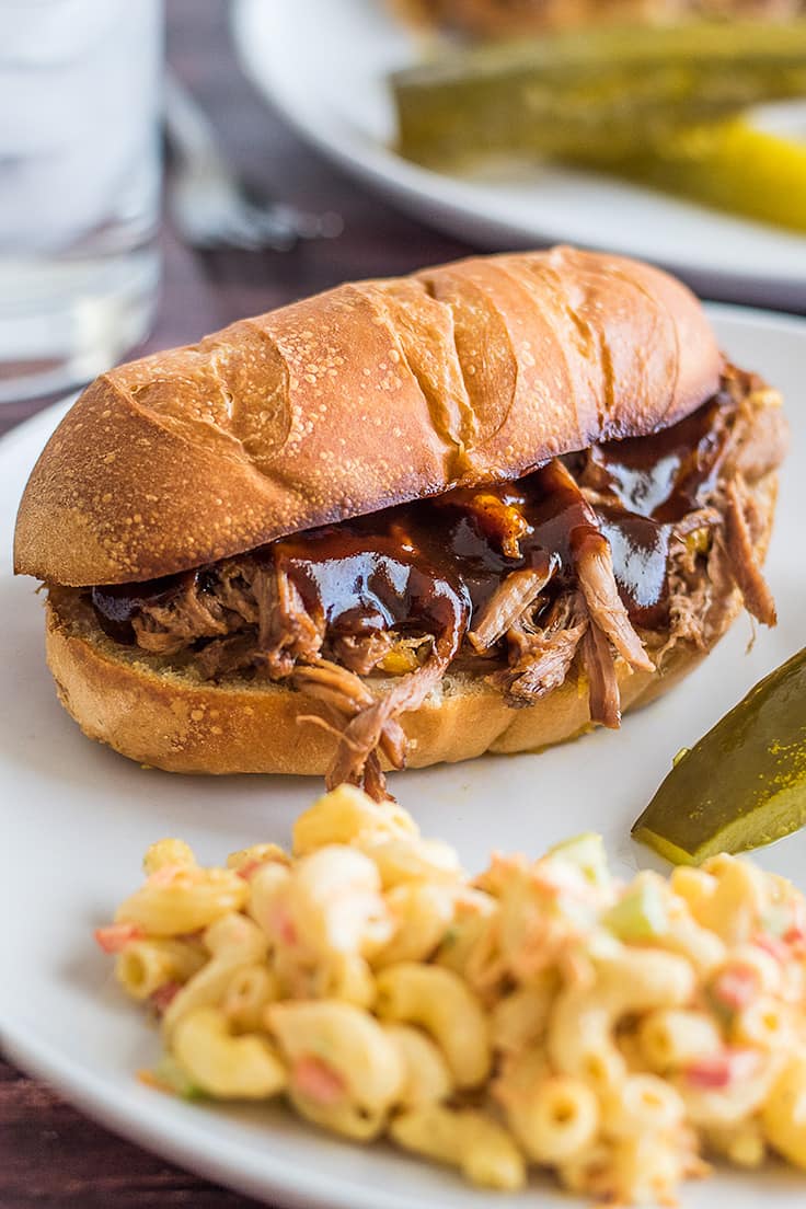 Slow cooker tri-tip sandwich on a white plate.