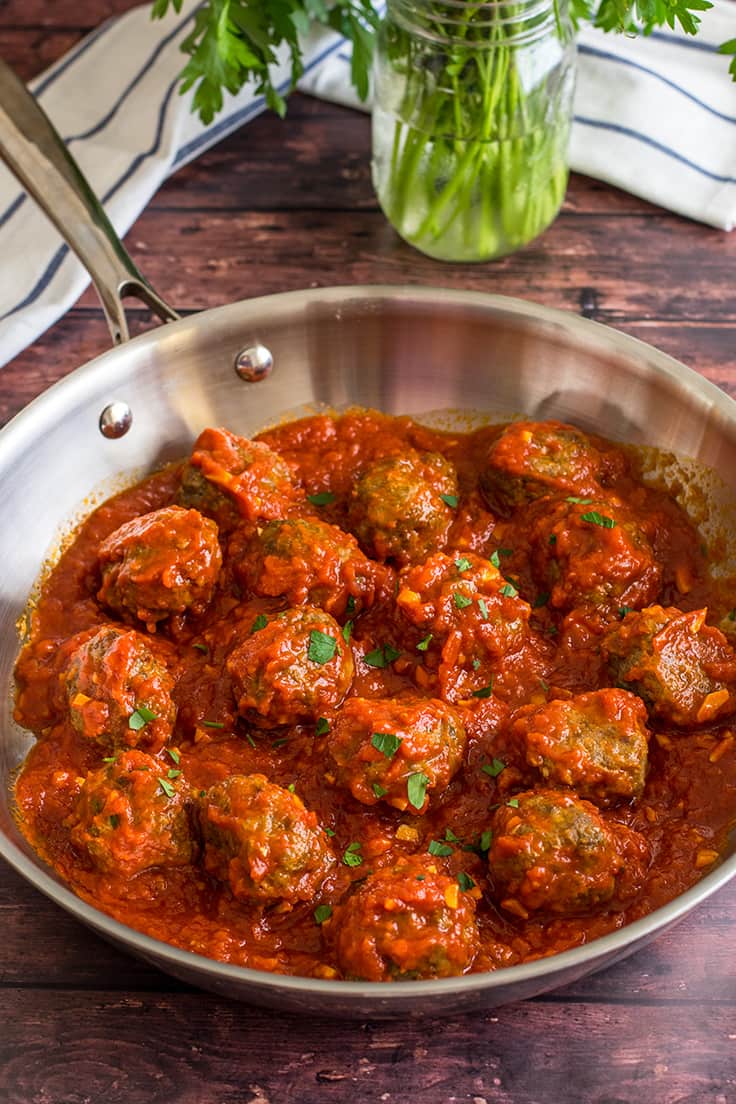 Meatballs in homemade marinara sauce in a skillet.