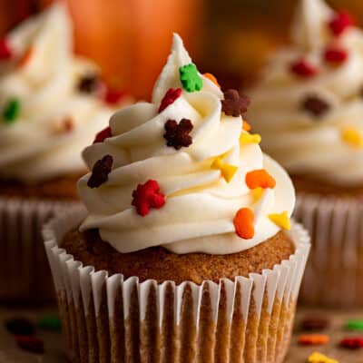 Small-batch pumpkin cupcakes with fall sprinkles on parchment paper.