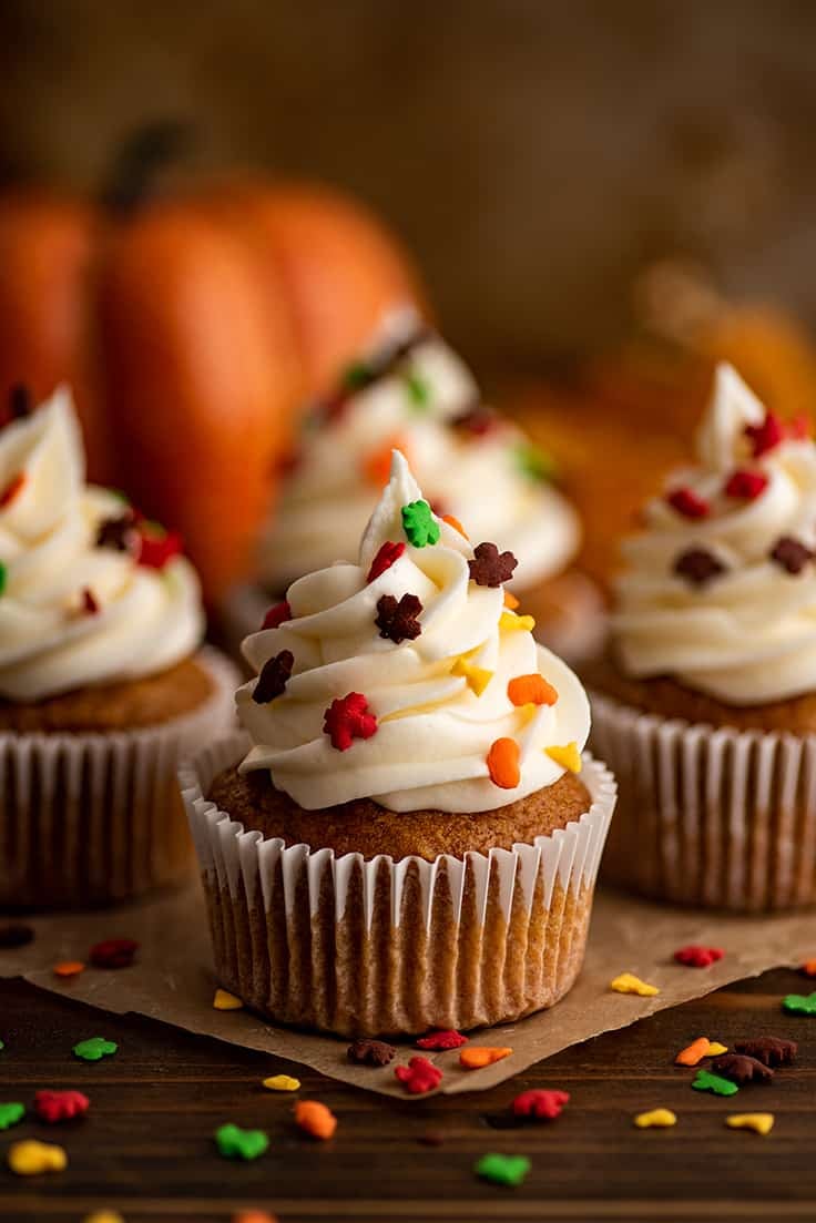Small-batch pumpkin cupcakes with fall sprinkles on parchment paper.